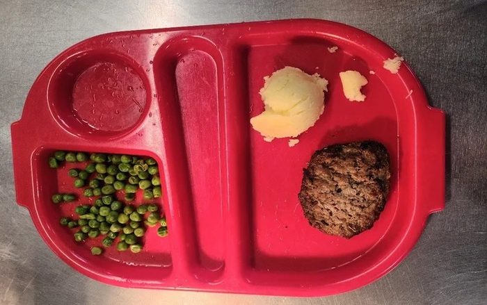 Burger, mash, peas and pepper sauce
